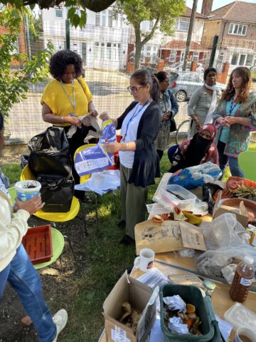 People gathered around a table with various gardening items and tools.
