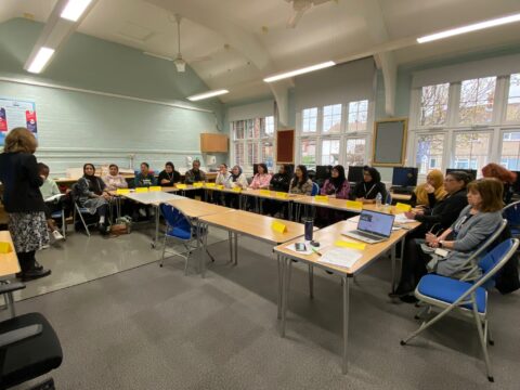 A group of people sitting around desks in a classroom